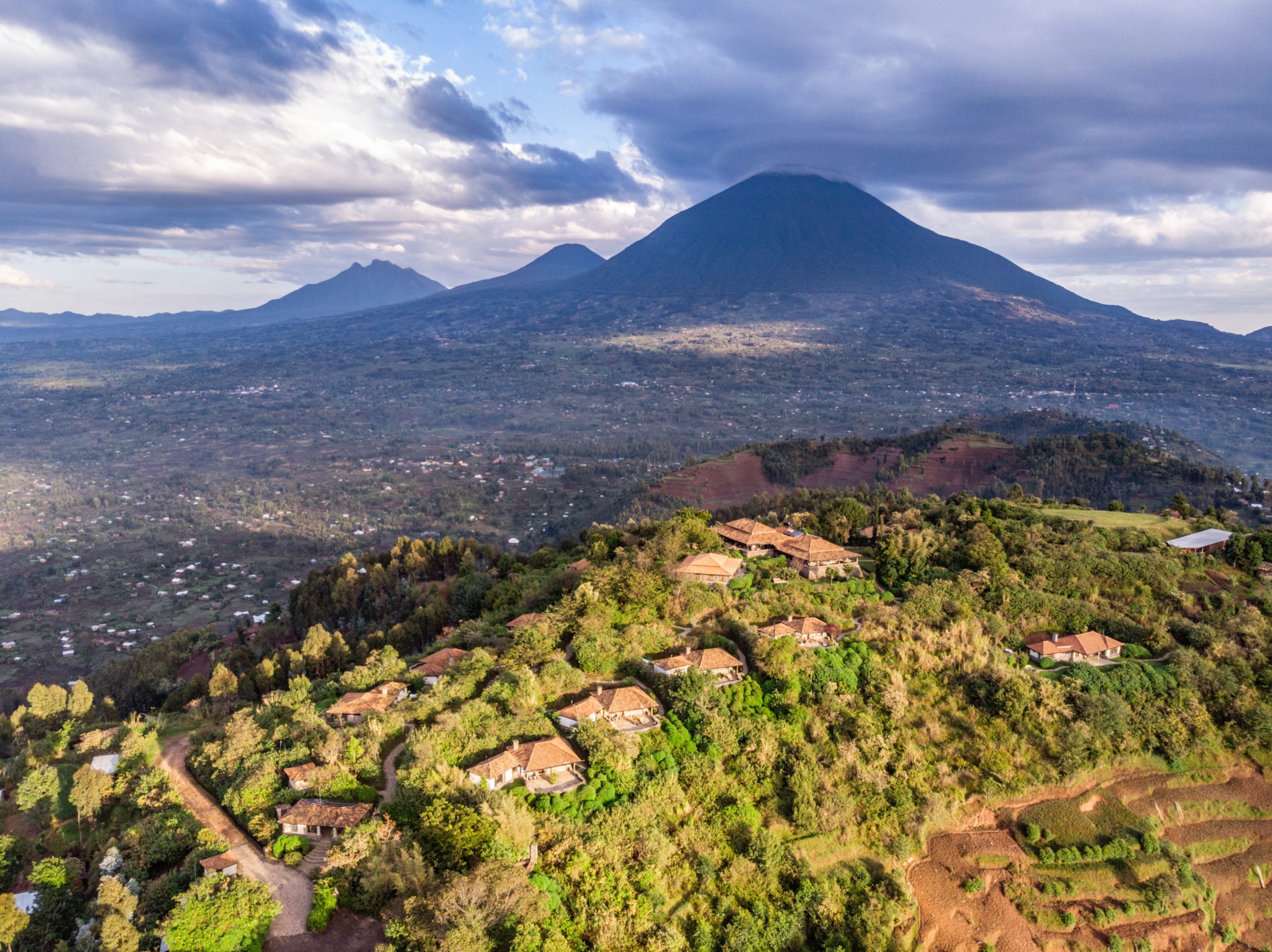 Aerial view of Virunga Lodge on its hilltop with a Virunga volcano behind, Rwanda